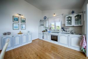 a large kitchen with white cabinets and a wooden floor at Seaview Suite Lissa in Vis