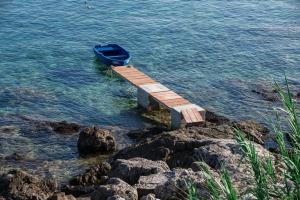 a blue boat sitting on a dock in the water at Seaview Suite Lissa in Vis