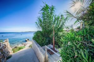 a bench sitting on a walkway next to the ocean at Seaview Suite Lissa in Vis