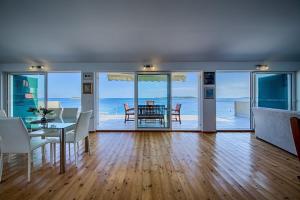 a living room with a table and chairs and the ocean at Seaview Suite Lissa in Vis