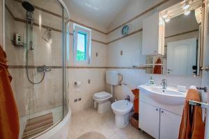 a bathroom with a toilet and a sink and a shower at Seaview Suite Lissa in Vis