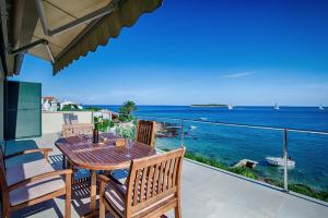 a table and chairs on a balcony with a view of the ocean at Seaview Suite Lissa in Vis