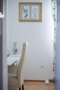 a white desk with a chair and a picture on the wall at Seaview Suite Lissa in Vis