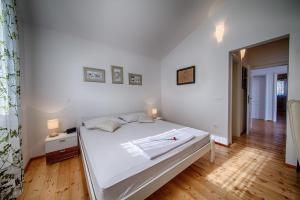 a bedroom with a white bed and a wooden floor at Seaview Suite Lissa in Vis