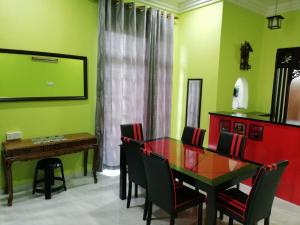 uma sala de jantar com uma mesa de vidro e cadeiras em Tiffana Homestay em Kampong Ayer Terjun