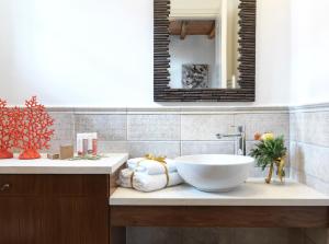 ein Badezimmer mit einem Waschbecken und einem Spiegel in der Unterkunft Plagia Villas in Finikas