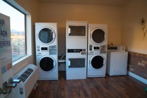 a laundry room with four washer and dryers in it at Broken Spur Inn & Steakhouse in Torrey