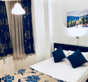 a bedroom with a bed with blue and white pillows at The House of Tulpan in Istanbul