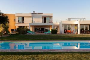 a house with a swimming pool in front of it at Amazing Windmillhouses in Olhão