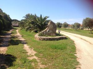 eine Steinskulptur an der Seite einer unbefestigten Straße in der Unterkunft Agriturismo Sa Ruda in Càbras