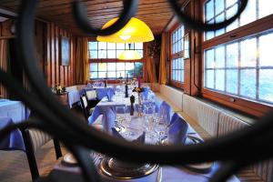 a dining room with a long table with chairs and glasses at Hotel Aristella Swissflair in Zermatt