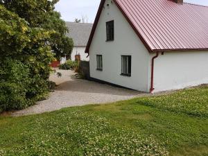 ein weißes Haus mit einem roten Dach und einem Hof in der Unterkunft Peterslund in Östra Tommarp