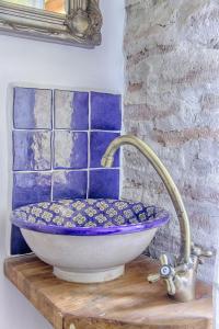 a bathroom sink with a blue and white bowl at Dominic Boutique - Atelier in Cloaşterf