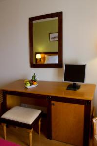 a desk with a computer on it and a chair at Hotel Quinta Bela S Tiago in Funchal
