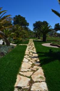a stone path in a park with palm trees at Relax in Vieste