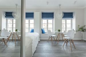 a bedroom with white furniture and a table and chairs at VIU Indigo Apartments in Gdańsk