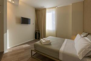 - une chambre avec un lit et une télévision murale dans l'établissement In Dies Affittacamere, à Matera