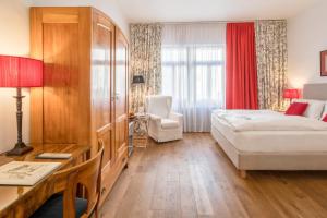 um quarto de hotel com uma cama, uma mesa e uma secretária em Hotel Deutscher Kaiser em Nurembergue