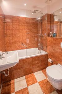 a bathroom with a tub and a toilet and a sink at Hotel Deutscher Kaiser in Nuremberg