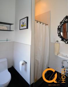a bathroom with a shower and a toilet and a sink at Q4 Hotel and Hostel in Queens