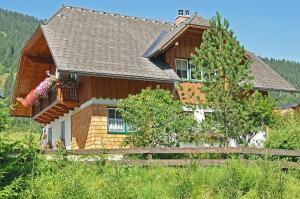 a wooden house with a fence in front of it at Landhaus Riesneralm in Donnersbachwald