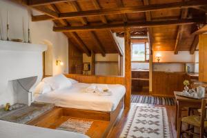 a bedroom with a bed in a room with wooden ceilings at Saxonis Houses & Saxonis Villa in Papingo