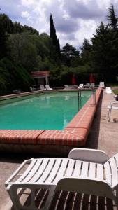 a large swimming pool with a bench and chairs at Hotel Zapata in La Cumbre