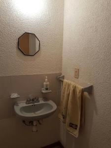 y baño con lavabo, espejo y toallas. en Casa Pachuca hidalgo, en Colonia de Venado