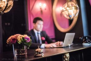 فندق جوزفين بونابرت في باريس: رجل يجلس على طاولة مع جهاز كمبيوتر محمول
