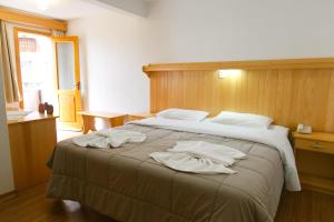 a bedroom with a large bed with towels on it at Hotel 13 Linden in Treze Tílias