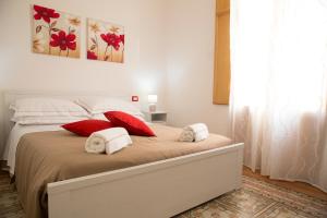 a bedroom with a bed with red and white pillows at Oltremare appartamenti in Trapani