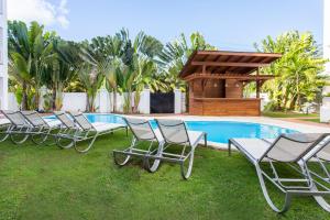 a row of lawn chairs sitting in front of a pool at Apartamentos Punta Cana by Be Live in Punta Cana
