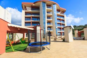 a large apartment building with a playground in front of it at Apartments Sunny Marina in Dobra Voda