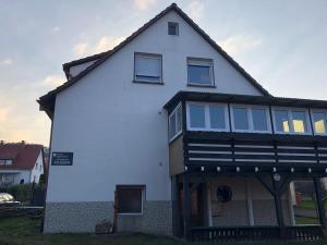 a white house with a black roof at FeWo 01 Bettenhausen in Morschen