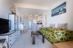 a living room with a couch and a tv and a table at Apartamento Balcón del Mar in Arenales del Sol