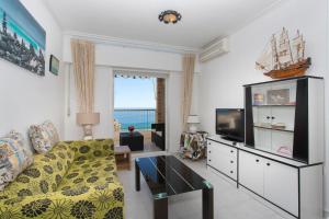 a living room with a couch and a tv at Apartamento Balcón del Mar in Arenales del Sol