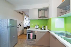 a green and white kitchen with a sink and a refrigerator at City Apartments in Sofia