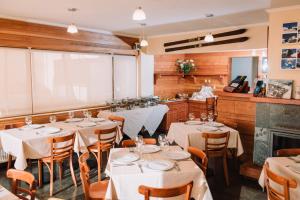 a restaurant with tables and chairs and a fireplace at Hotel Chalet Valluga in Farellones