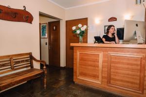 uma mulher a falar ao telefone na recepção em Hotel Chalet Valluga em Farellones