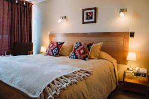 um quarto com uma cama grande e uma cabeceira em madeira em Hotel Chalet Valluga em Farellones mais 37 fotografias