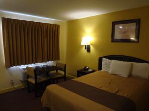 um quarto de hotel com uma cama e uma cadeira em Americas Best Value Inn - Goldsboro em Goldsboro