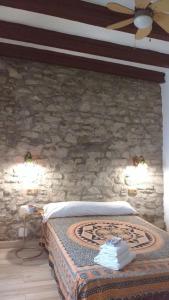 タリファにあるLA MIRILLA SUITES 3の石壁のベッドルーム1室(ベッド1台付)