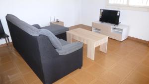 a living room with a couch and a table and a tv at Chalet Verde in Tavernes de Valldigna