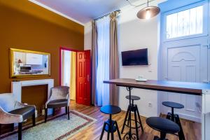 ブダペストにあるQuiet Romantic Flat in Centerのスツールと赤いドアのあるバー付きの部屋