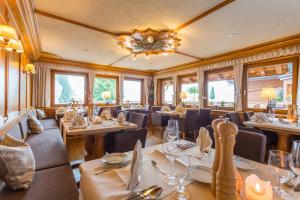 a restaurant with tables and chairs and a chandelier at Hotel Schlehdorn in Feldberg