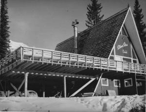 a large building with a deck in the snow at The Pinnacles Suites & Townhomes in Silver Star