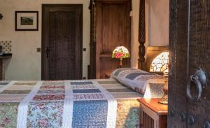 a bedroom with a bed with a quilt on it at Mas Tulsà Casa Rural Girona in Riudellots de la Creu