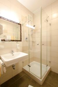 W łazience znajduje się umywalka i prysznic. w obiekcie Gasthof Hotel Jägerwirt w mieście Strasswalchen