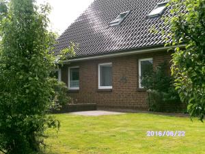 a brick house with a grass yard in front of it at Haus Sonja in Büsum
