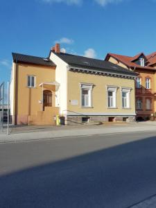 una casa amarilla y blanca al lado de una calle en Ferienwohnung am Torbogen Nr.2, en Lübbenau